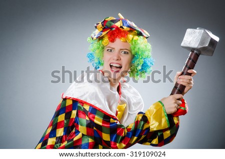 Clown with hammer in funny concept