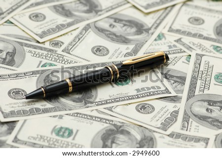 Black ballpoint pen over the dollar bank  notes
