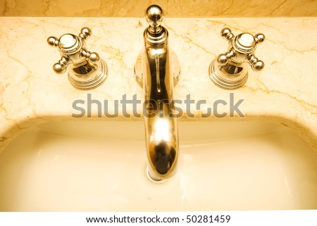 Silver shiny tap and marble sink