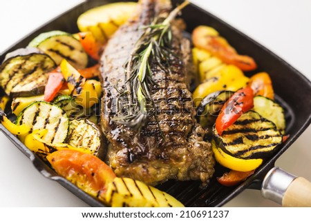 beef steak with grilled vegetables in skillet