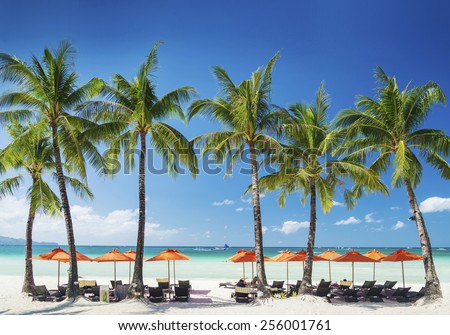 white beach lounge bar chairs and umbrellas on boracay tropical island in philippines