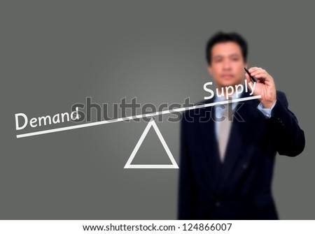 business man writing demand and supply compare on balance bar