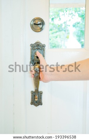 Hand on a handle wooden door to open or close it.
