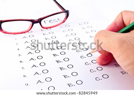 Hand on pencil choosing the test list and glasses on the examination