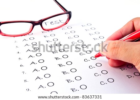 Hand on pen choosing the test list and glasses on the examination