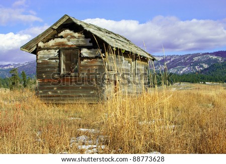 Deserted Cabin:  An old wooden cabin, falling to ruin, stands on a grassy hillside.