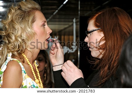 Female model making up for a fashion show backstage