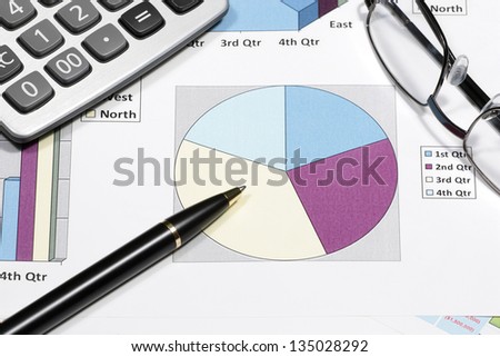 business financial chart analysis with pen eyeglasses & calculator on paper work