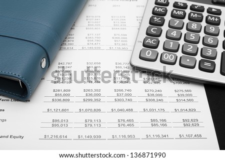 business financial chart analysis with notebook & calculator on paper work