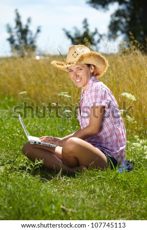 Happy attractive female work on her laptop, summer outdoor shoot