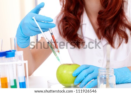 Female lab assistant during food modification , isolated on white