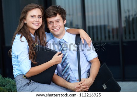 Portrait of a smiling attractive business young couple with briefcase, outdoor shoot