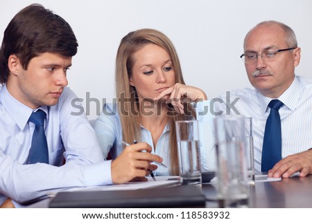 Group of business people sitting together on the table and discuss, background in the office