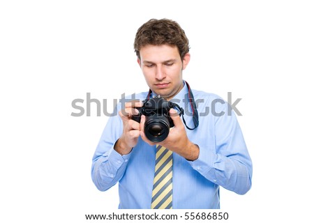 young photographer checks photos on back screen of his dslr camera, studio shoot isolated on white background