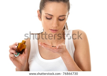 stressed attractive young brunette take some pills, holds small brown vial for pills, isolated on white