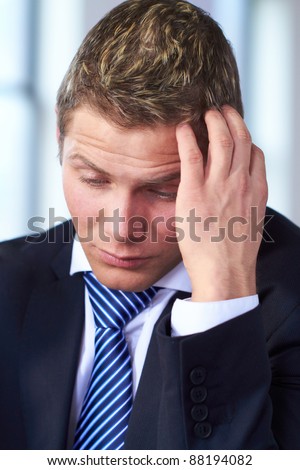 Young worried and stressed businessman scratch his head, very sad face expression