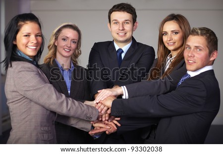 Group of 5 businesspeople hold their hands together, unity and teamwork concept