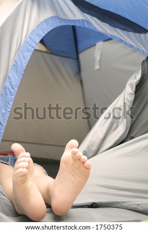 child\'s feet hanging out of tent