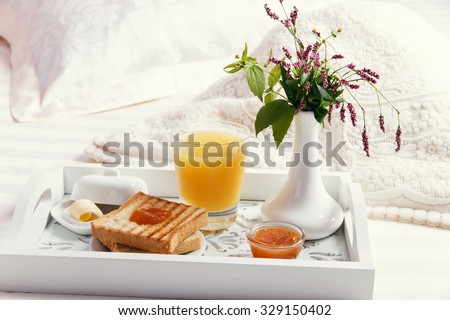 breakfast on wooden tray on the bed