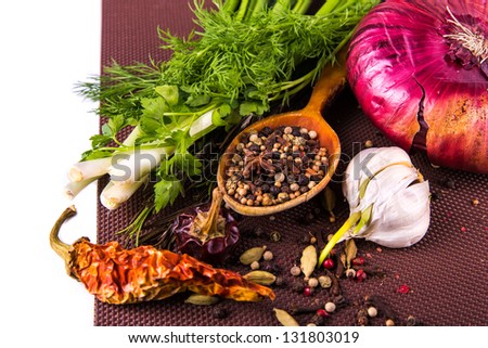 Various spices and herbs, onion and garlic isolated on white