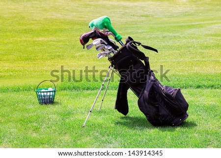 Professional golf equipment  in a golf cart and bucketful of balls on the golf course