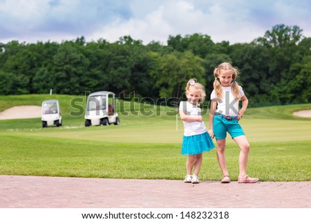 Cute little sportive girls on the golf course