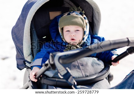 Cute little baby in a stroller outdoor in winter