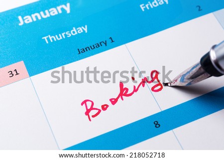 Booking word written on the calendar with a pen