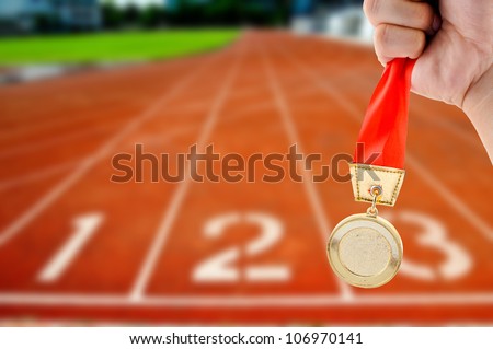 Athletic holding golden medal in Start Running track