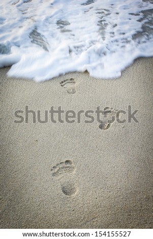 Foot print stamped on the beach to  play sea