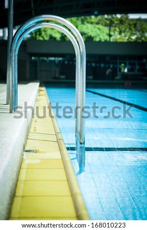 Close up Grab bars ladder of blue standard competition pool.