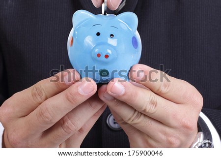 Businessman holding  Piggy bank officer put money inside for invest in the future