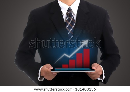 Businessman holding touch pad for show case growing graph