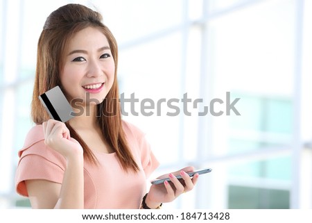 Portrait lovely girl type information with her  Credit card and  mobile phone  in Shopping mall