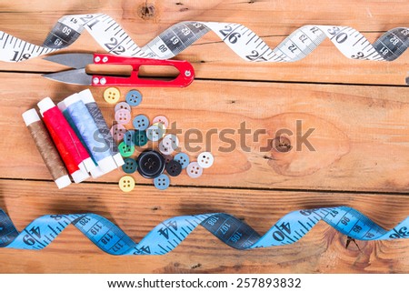Yarn scissors ,measuring tape and Yarn Sewing with wood background