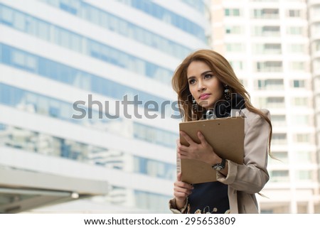 Businesswoman note and think her job with wood board.