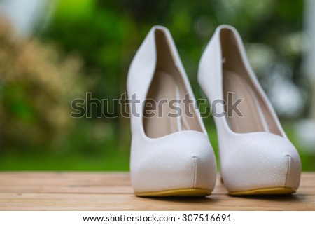 Woman shoes fashion on wood table in the garden.