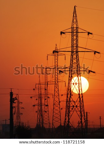 Power lines poles over setting sun