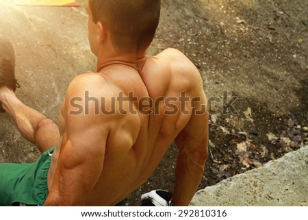 Close up on hands and back muscles, young man  Outdoor workout, training outside , strong bodybuilder