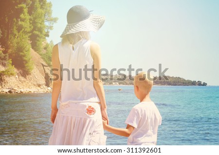Mother and son on the beach. Woman and boy son in front of sea, active summer holiday vacation, family travel photo