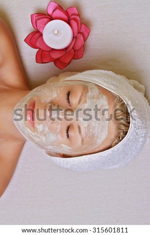 Young beautiful girl receiving clay facial mask in spa beauty salon.  Skin care, Beauty treatments.