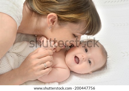 close-up portrait of mother tenderly keeping her baby hands and touching face to face