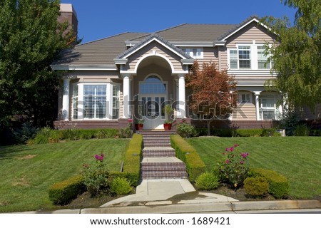 External shot of a traditional home that has a well designed entry and nice landscaping.
