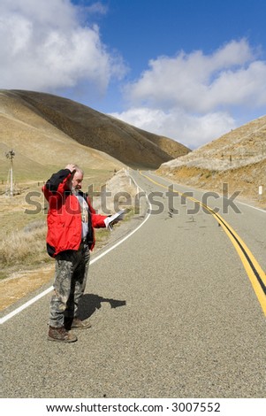 Man trying to find his location... lost on a desolate road.
