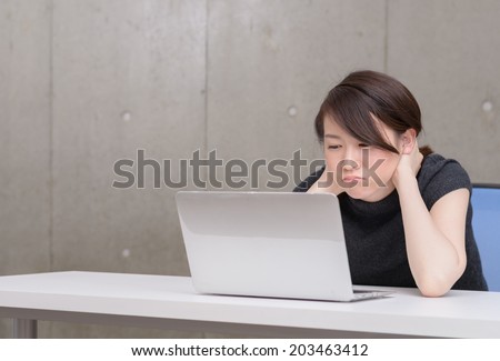 Young Asian woman depressed to watch a laptop computer.