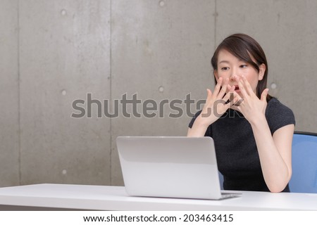 Young Asian woman  surprised to watch a laptop computer.