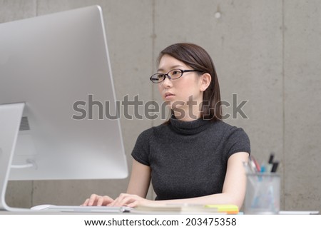 Young Asian woman working with a desktop computer.