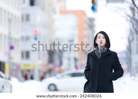 Young Asian woman walking on a winter city.