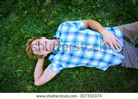 Young man is having a rest on the grass