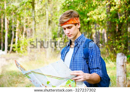 Young man is exploring the map being in the forest